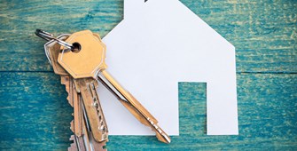 Set of keys on top of a paper cut-out of a house
