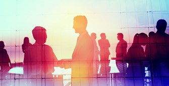 Shadows of people shaking hands and conversing over a colorful background