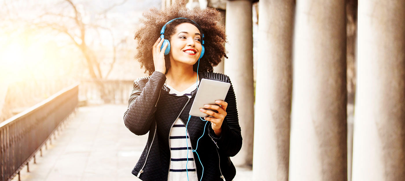 Woman with tablet listening with headphones 